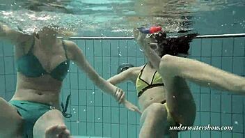 Softcore lesbians swim together in the pool