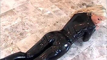 Sexy queen Hollys shows off her kinky side in a black latex catsuit and high heels