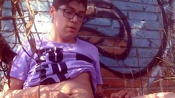 A hot naked boy jerks off outdoors