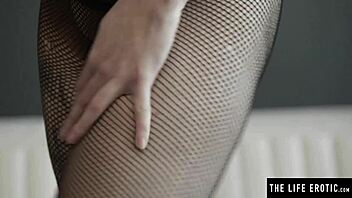 Finger a petite babe's shaved pussy while watching her strip and play with fishnets