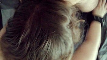 a young woman gives a blindfolded blowjob in a private setting.