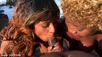 Nina Rivera and Porsha Carrera blow dick on rocks.