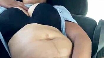 ebony woman fingers wet pussy in public car, teasing passersby with risky outdoor masturbation