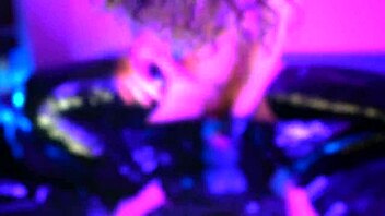 barefoot woman in latex plays at home with toys