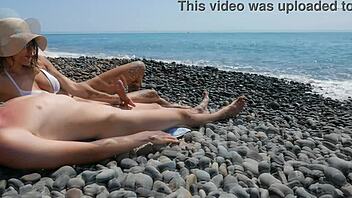 Млад непознат доставя гореща ръчна работа на див публичен гол плаж.