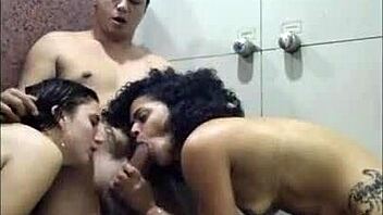 Two hot and sexy babes engage in a steamy threesome in a motel shower