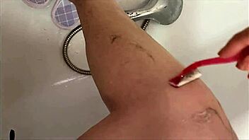 Cute amateur with hairy legs enjoys shower and shaving in close-up video