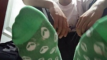 Twink shows off long green socks and sweaty feet up close