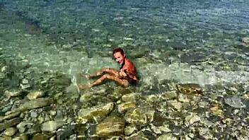 Slender tanned blonde enjoys a steamy beach session during her photo shoot