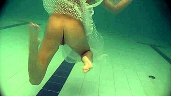 Natalia, a young Russian babe, swims and strips in a poolside video