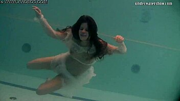 Natalia, a young Russian babe, swims and strips in a poolside video