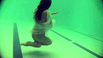 Natalia, a young Russian babe, swims and strips in a poolside video