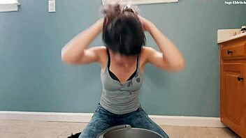 Brunette flips wet hair in soaked t-shirt and jeans