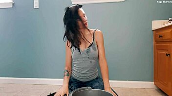 Brunette flips wet hair in soaked t-shirt and jeans