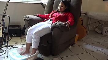 An asian woman receives a relaxing foot bath massage.