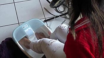 An asian woman receives a relaxing foot bath massage.