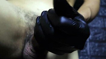 Close-up handjob with gloves on a big cock