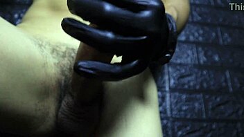 Close-up handjob with gloves on a big cock