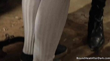 Blonde woman humiliated and dominated by femdom in dungeon