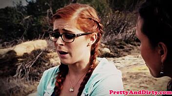 A redheaded woman experiences double penetration in a threesome scenario