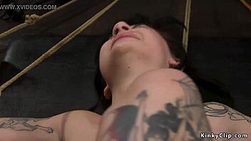 Tattooed person tied up in a rough session at home.