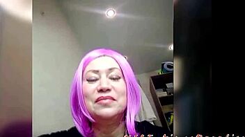A stunning and mature woman with purple hair indulges in self-pleasure through her delicate lingerie