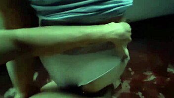 A Colombian couple engages in outdoor urination while on their balcony during a rainstorm