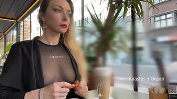 Exposed breasts in a transparent t-shirt at a glass-walled café for all to see