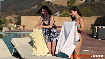 Brunette Women Kissing by the Pool Outdoors