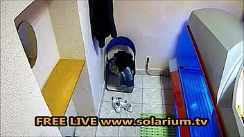 MILF masturbates with big breasts under solarium