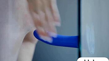two luscious babes playing with a blue dildo together