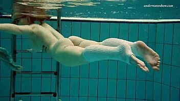 dasha dives naked underwater in a public pool. a petite teen’s bold display.