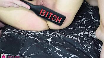 Rough spanking and masturbation on shaved pussy in garage with paddle and straps