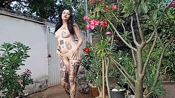 Tattooed woman fully naked showing off her hairy pussy and big ass.