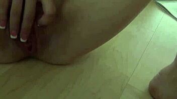 A beautiful young woman with an angelic face has a tattoo and she is masturbating while being filmed