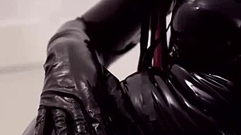 in the dark room, the fetish shemale in latex suit and mask starts fucking with her monster cock, building up to a cumshot