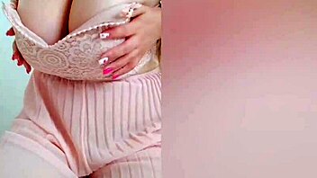 Young cutie in pink dress teases her big tits on camera