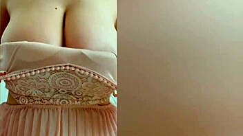 Young cutie in pink dress teases her big tits on camera