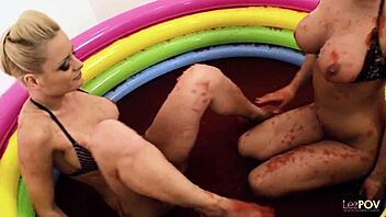 Cheerful babes play with jello in the pool and finger each other