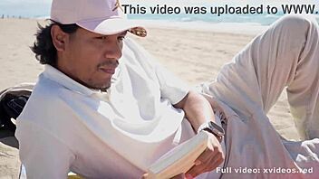 A young man enjoys the calm weather while a woman seduces him on the beach
