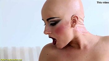 Bald head Luca Bella rocks a steamy latex corset for your eyes.