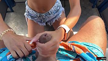 Close up of a beautiful young woman giving a blowjob on a Ferris wheel in an amusement park