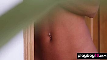 Petite ebony Agatha strips for Playboy, spreading legs to show her tight pussy.