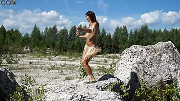 Topless mature woman dances gracefully in white stone quarry