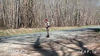 Lingerie clad redhead posing by the road