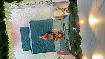 Monika Fox poses naked on the bed, showcasing her pierced nipples and big tits.