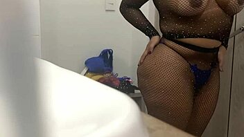 A blonde beauty in her prime shows off her curves as she changes into a dress