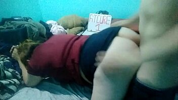 Latina woman bends over on bed