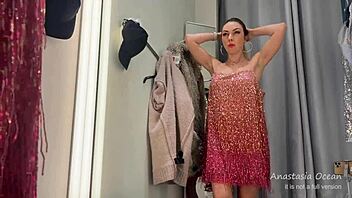 Hot slut flashes her sexy body while trying clothes in public fitting room.