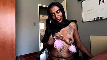 An amateur Indian woman wears a hijab and has pierced nipples while she smokes